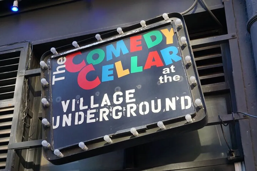 The image shows a colorful and illuminated sign for The Comedy Cellar at the Village Underground.
