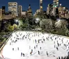 A group of people are enjoying ice skating with a smiling woman in the center balancing herself while another person appears to be bending down or falling in the foreground