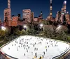 A group of people are enjoying ice skating with a smiling woman in the center balancing herself while another person appears to be bending down or falling in the foreground