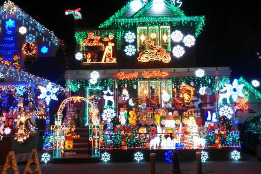 A house is extravagantly decorated with a variety of colorful Christmas lights and festive displays, creating a bright and elaborate holiday spectacle.