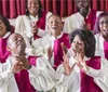 A joyful choir wearing white and red robes is singing and clapping with expressive and happy faces