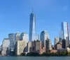 The image features the Statue of Liberty in the foreground with the New York City skyline including One World Trade Center in the background under a partly cloudy sky