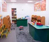 The image shows an indoor playground with colorful floors and scattered soft balls featuring play structures for childrens entertainment