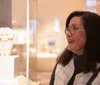 A person is admiring an exhibit within a glass display in what appears to be a museum setting