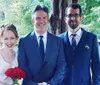 A joyful couple walks through an archway as guests throw flower petals to celebrate their wedding