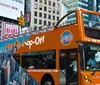 Tourists on an open-top bus at night are taking photos of the vibrant street scenes and bright neon lights in Times Square New York