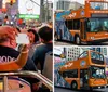 Tourists on an open-top bus at night are taking photos of the vibrant street scenes and bright neon lights in Times Square New York