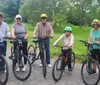 Five individuals spanning multiple generations are posing with their bicycles in a park ready for a family bike ride