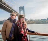 Two people are enjoying a scenic boat ride with a backdrop of colorful autumn foliage