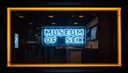 The image shows the brightly lit neon sign for the 