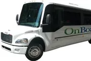 The image shows a white shuttle bus with the word 