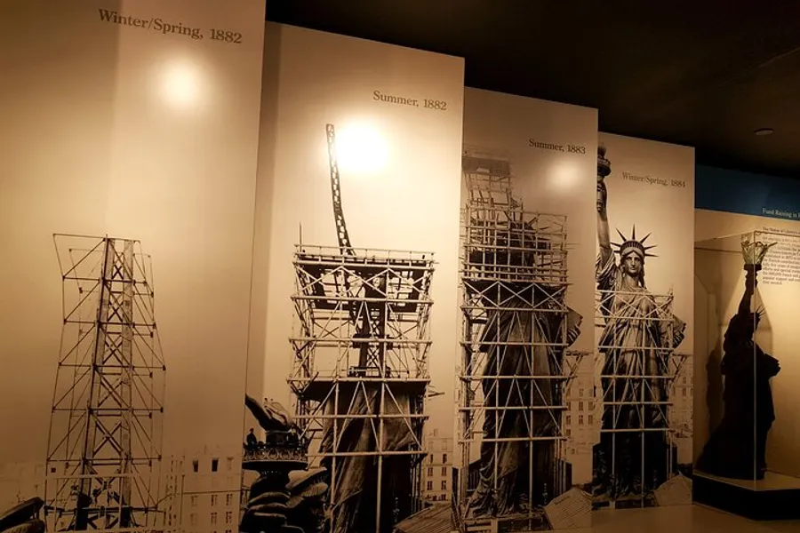 This image showcases a series of panels depicting the construction phases of the Statue of Liberty over time, from its initial framework in winter/spring 1882 to its completion in winter/spring 1884.