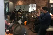 A group of musicians is performing live in a cozy venue with an audience enjoying the atmosphere.
