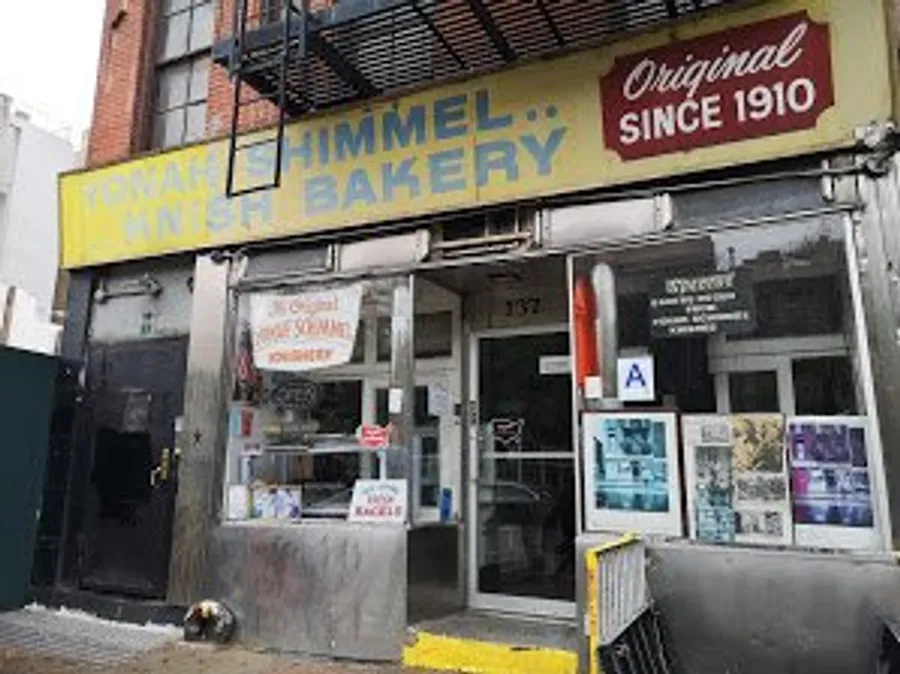The image shows an old-fashioned bakery storefront with signage indicating it has been operating since 1910, and it has a health grade A displayed on the window.