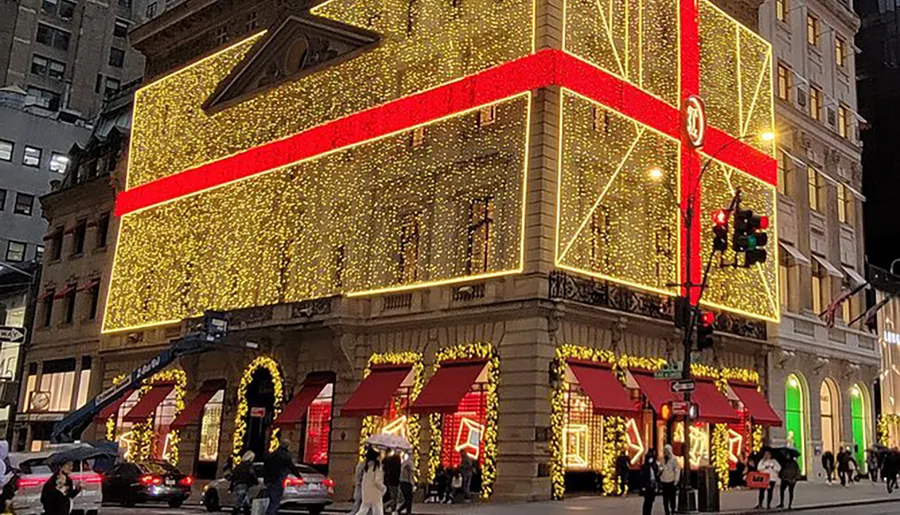 A building is extravagantly decorated with shimmering lights and red ribbons, creating a festive atmosphere suggestive of holiday celebrations.