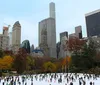 A group of people is enjoying their time on an ice skating rink with a smiling woman in the foreground showing off her balance while another person appears to be bending down or falling in the foreground